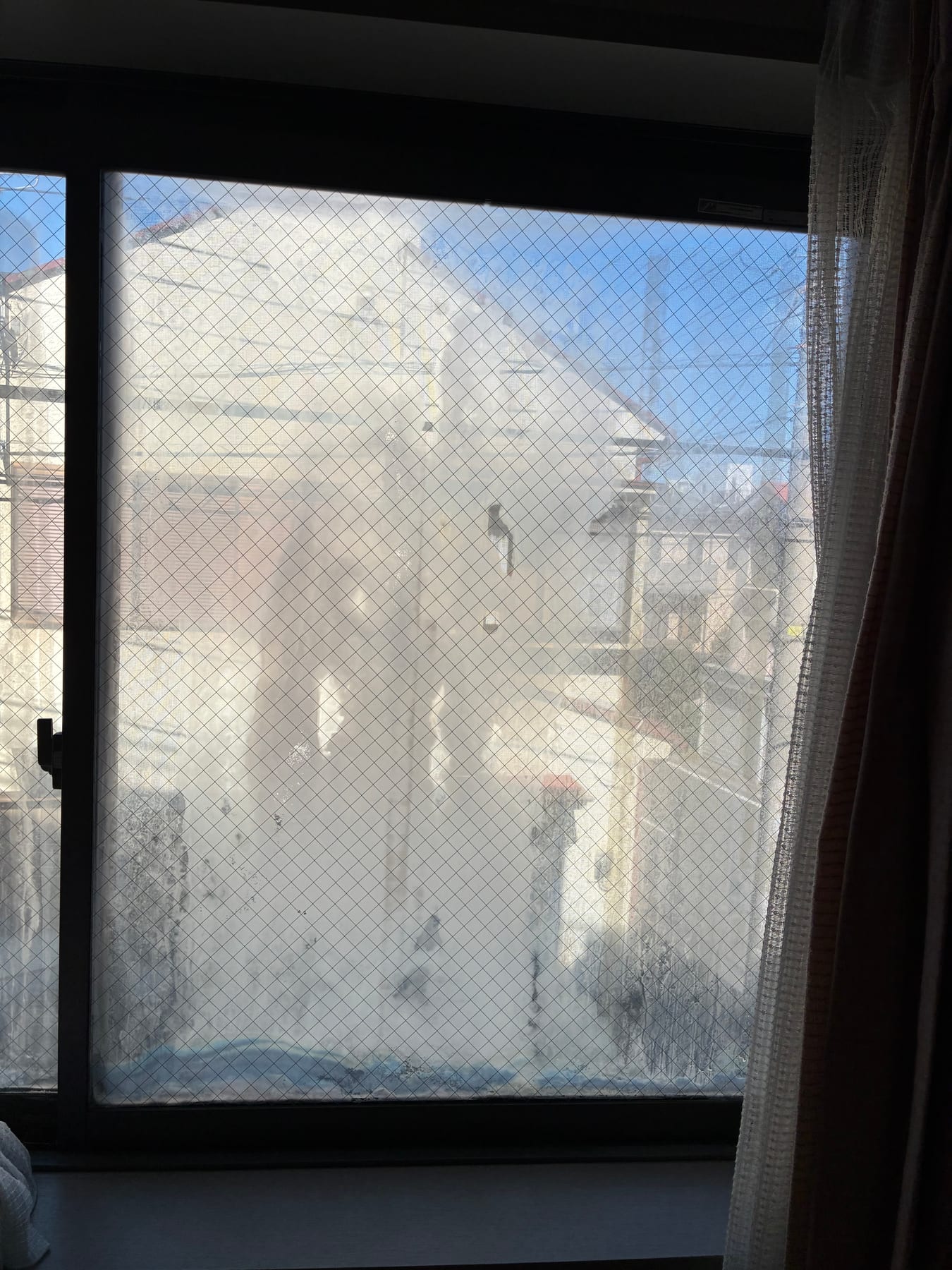 ガラス越しの景色が白く曇って見える窓